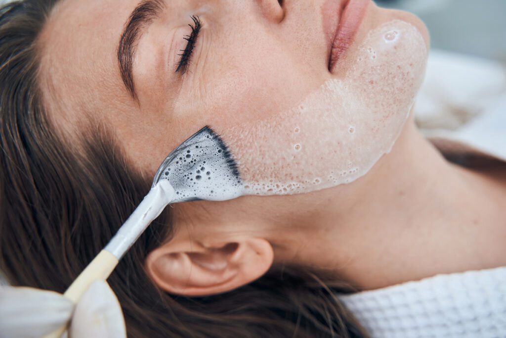 Profesional realizando un tratamiento de estética, ilustrando cómo iniciarte profesionalmente en el cuidado facial y corporal.