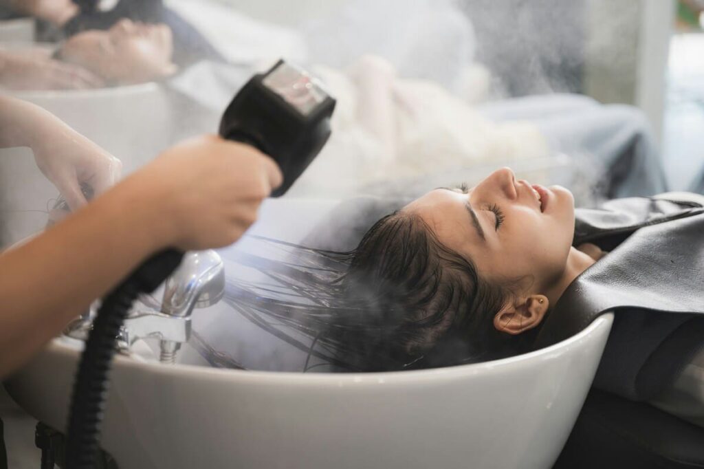 Especialista aplicando un masaje relajante para fidelizar clientes a través de tratamientos de spa capilar.