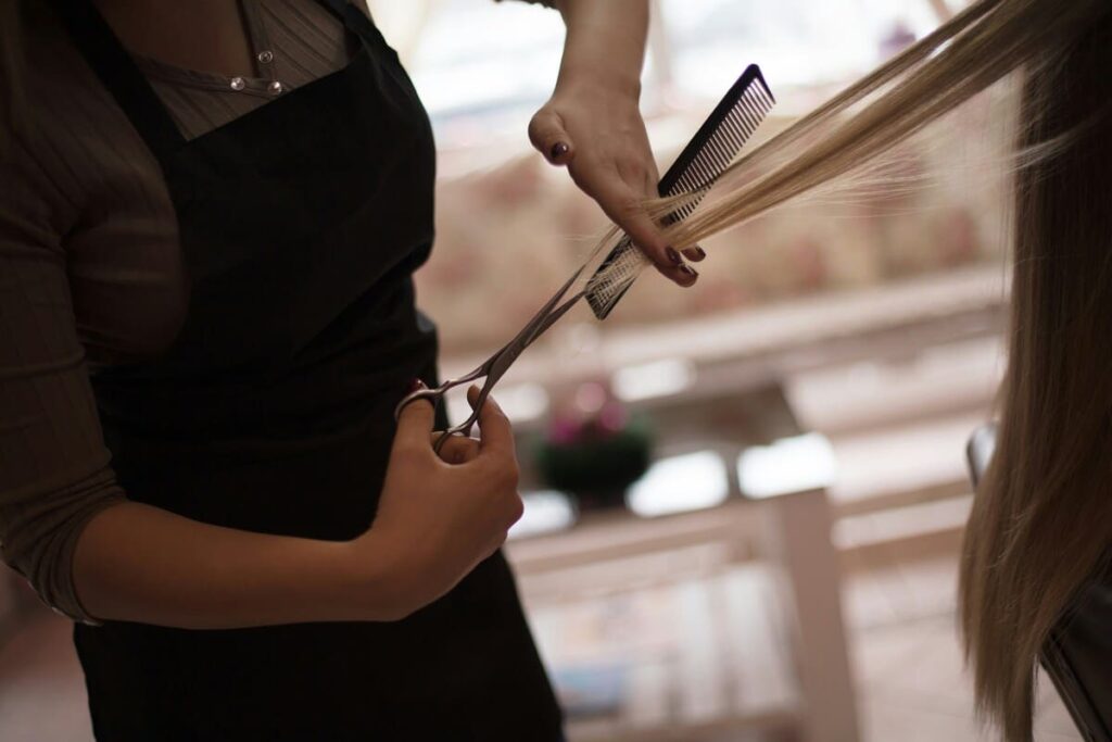 Peluquera profesional aplicando Técnicas de texturización con tijeras de entresacar.